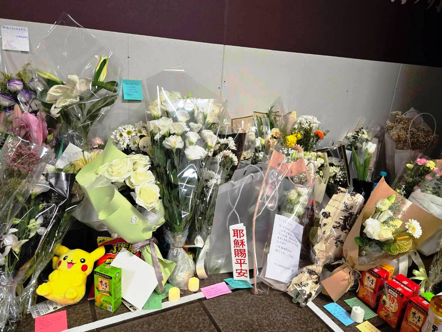 北車M7和M8出口處，有民眾擺放電子蠟燭，鮮花和耶穌賜你平安的牌子，為台灣祈禱。（圖/梁敬彥攝影）